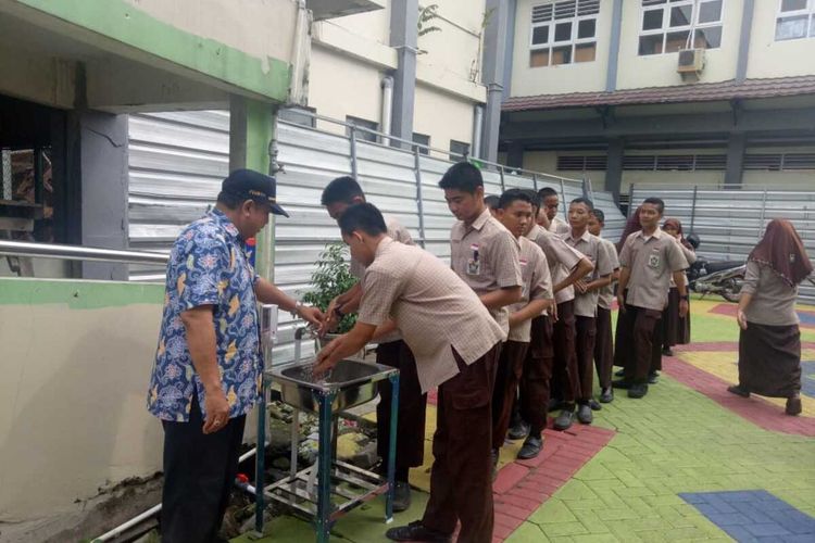 Sejumlah siswa sekolah menengah pertama di Surabaya memanfaatkan wastafel yang disediakan Pemerintah Kota Surabaya untuk cuci tangan, Jumat (6/3/2020).
