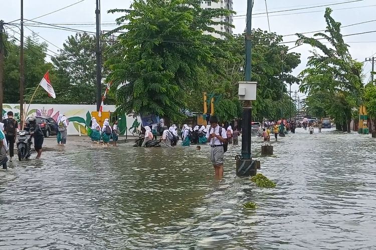 Sejumlah pelajar sekolah dan warga di lokasi terjadinya banjir di Jalan Dr Mansyur, Medan, Kelurahan Selayang I, Kecamatan Medan Selayang pada Kamis (18/8/2022).