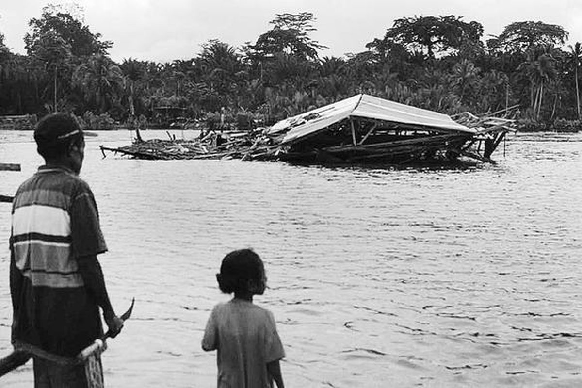 Yulius Arubaya (60) bersama cucunya, warga Kampung Warironi, Distrik Ampimoi, Kabupaten Kepulauan Yapen, Papua, Jumat (18/6), hanya mampu mengamati tempat tinggalnya yang roboh akibat guncangan gempa berkekuatan 7,1 skala Richter pada 16 Juni lalu. Di kawasan ini sekitar 200 rumah warga hancur akibat gempa dahsyat tersebut.