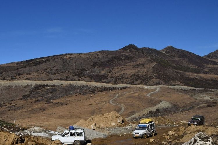 Gambar yang diambil pada tanggal 4 Desember 2021 ini menunjukkan para turis yang berkendara di sepanjang jalan menuju Air Terjun Chumi Gyatse, juga dikenal sebagai Air Terjun Suci di dekat Garis Kontrol Aktual (LAC) tetangga China, di distrik Tawang di negara bagian Arunachal Pradesh, India.