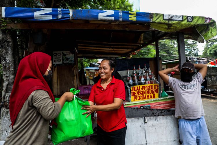 Relawan membagikan paket sembako kepada warga di Jalan Garnisum RT 003/RW 04, Kelurahan Karet Semanggi, Kecamatan Setiabudi, Jakarta Selatan, Selasa (21/4/2020). Pemerintah menggelontorkan dana bansos untuk warga rentan miskin Jakarta yang terdampak wabah COVID-19, dialokasikan untuk 2,6 juta jiwa atau 1,2 juta kepala keluarga. Pemberian bantuan ini merupakan upaya pemerintah untuk mencegah warga tidak mudik dan meningkatkan daya beli selama wabah covid-19.