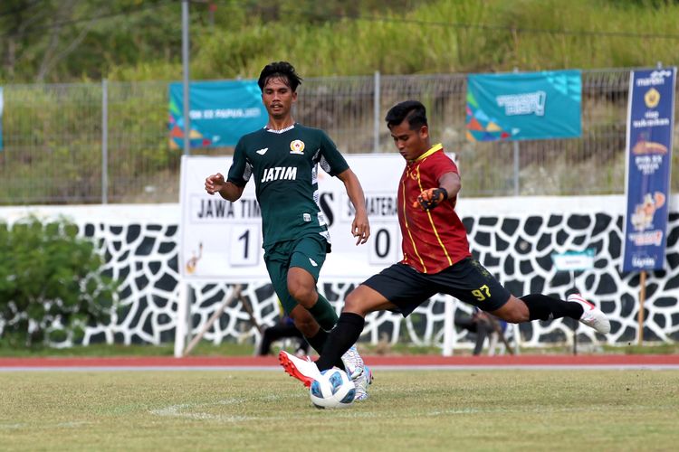 Penjaga gawang Sumatera Utara (kanan) menghalau bola pemain Jawa Timur (kiri) saat babak penyisihan grup B PON XX Papua 2021 yang berakhir dengan skor 2-0 di Stadion Mahacandra Kota Jayapura, Senin (4/10/2021) sore.