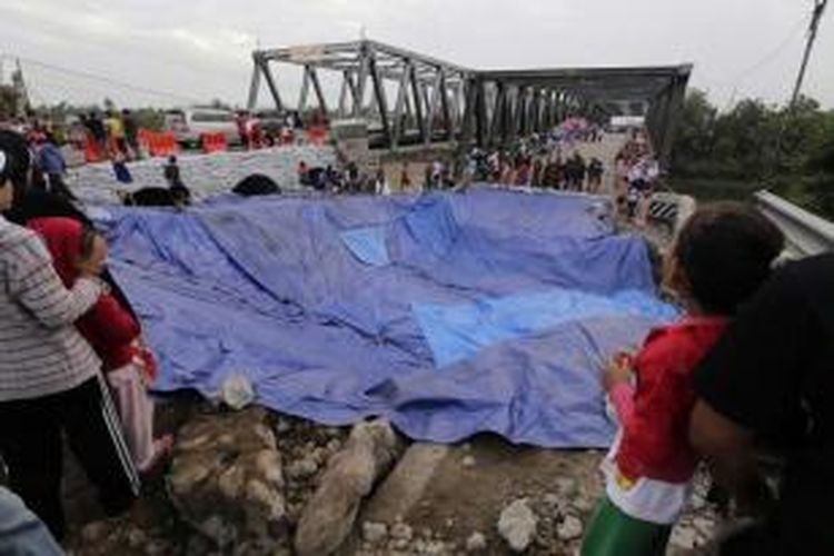 Warga menyaksikan dibukanya kembali Jembatan Comal Pantura, Pemalang, Jawa Tengah, di jalur Jakarta ke Surabaya, Kamis (24/7/2014). Lalu lintas untuk jalur Surabaya - Jakarta masih diarahkan ke jalan alternatif, karena sisi jembatan selatan masih belum selesai diperbaiki.