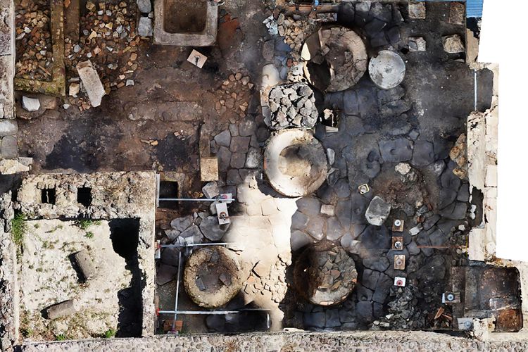 Foto yang dirilis pada tanggal 8 Desember 2023 oleh taman arkeologi Pompeii ini, menunjukkan area Regio IX di situs tempat ditemukannya toko roti penjara, demikian diumumkan taman arkeologi pada hari yang sama. Menurut para sejarawan, pabrik roti itu adalah tempat di mana orang-orang yang diperbudak dan keledai dikurung dan dieksploitasi untuk menggiling biji-bijian yang dibutuhkan untuk membuat roti. Sebuah ruangan sempit tanpa pemandangan ke luar, dengan jendela-jendela kecil dengan kisi-kisi besi untuk masuknya cahaya. Dan di ukiran lantai untuk mengkoordinasikan pergerakan hewan-hewan, dipaksa berjalan berjam-jam dengan penutup mata.