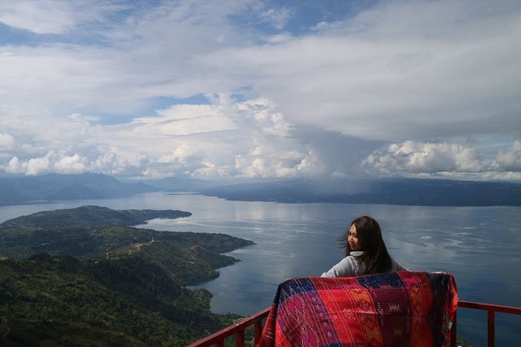 Pengunjung sedang menikmati pemandangan Danau Toba di Huta Ginjang di Kabupaten Tapanuli Utara
