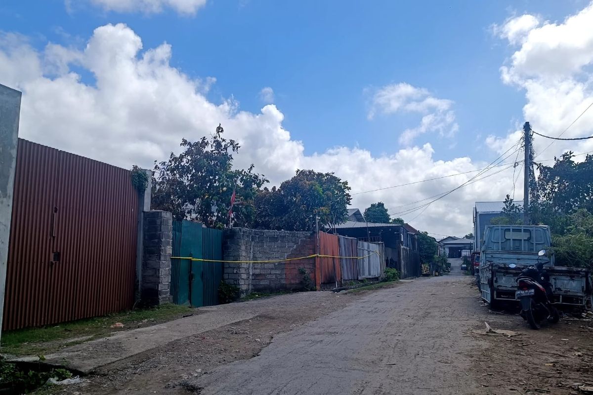 Polisi memang garis polisi di sekeliling tembok gerbang Gudang elpiji  di Jalan Cargo II nomor 6, Kelurahan Ubung Kaja, Kecamatan Denpasar Utara, Kota Denpasar, Bali, yang dilanda kebakaran pada Minggu (9/6/2024) pagi. Kompas.com/ Yohanes Valdi Seriang Ginta