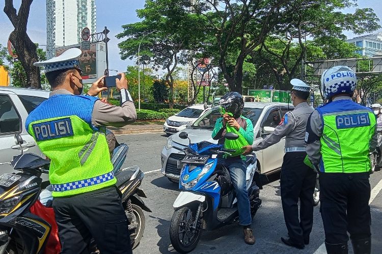 Satlantas Polres Tangerang Selatan membagikan brosur keselamatan berlalulintas, helm, dan sembako kepada sejumlah pengguna jalan yang melintas di Jalan Pahlawan Seribu, German Center BSD, Tangsel, Senin (3/10/2022) saat operasi zebra jaya.