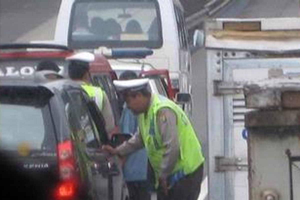 Ilustrasi: Polisi lalu lintas menilang pelaku pelanggaran yang menggunakan bahu jalan bebas hambatan (tol). 