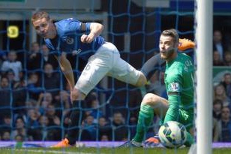 Gelandang Everton James McCarthy (kiri) mencetak gol ke gawang Manchester United yang dikawal David de Gea (kanan) pada laga Premier League di Stadion Goodison Park, Liverpool, Minggu (26/4/2015).