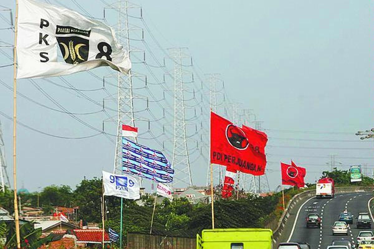 Bendera partai politik berukuran besar berkibar tertiup angin di pinggir jalan tol di kawasan Ancol, Jakarta Utara, Sabtu (4/10). Pemasangan bendera partai politik dan nomor urutnya di tiap sudut Jakarta yang tidak tertata rapi membuat pemandangan semrawut.  