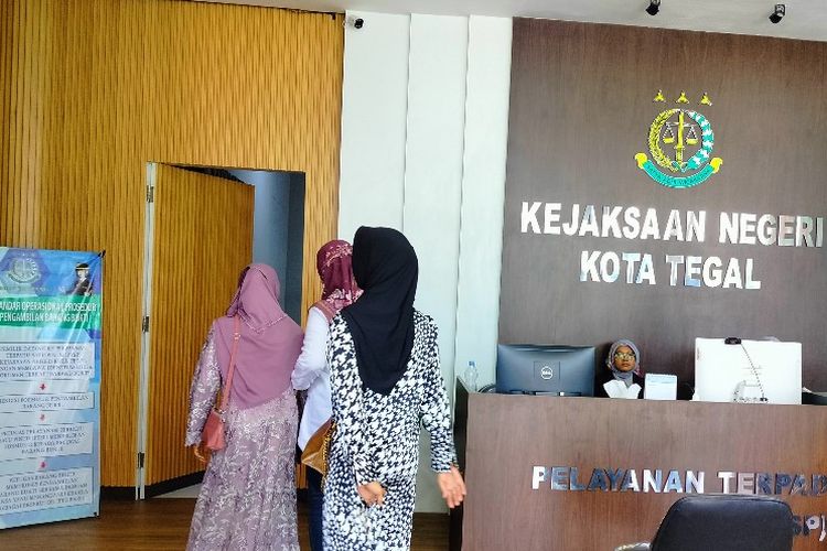 Seorang perempuan tersangka pemalsuan surat hingga diterbitkannya SHM didampingi pihak keluarga diserahkan pihak kepolisian ke Kejari Kota Tegal, Jawa Tengah, Kamis (22/2/2024).