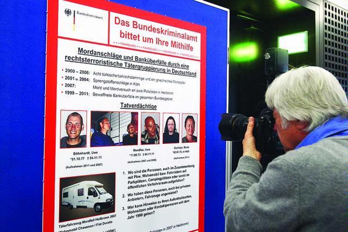 Fotografer  mengambil gambar dari daftar orang-orang yang  dinyatakan dicari di sebuah dinding pengadilan di  Karlsruhe, Jerman, Kamis (1/12). Pemunculan gambar orang-orang yang dicari ini terkait dengan perburuan polisi Jerman terhadap teroris dari kubu neo-Nazi. 