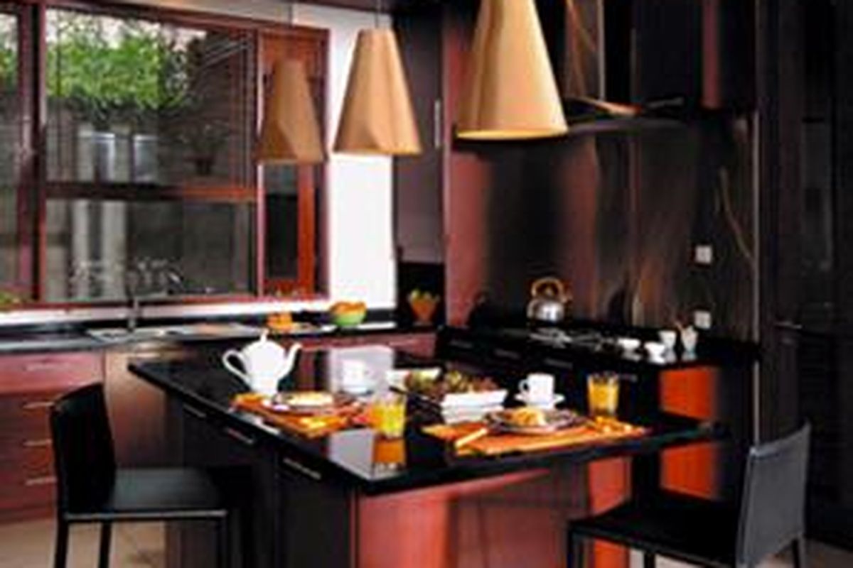 Pemilihan warna gelap untuk furniturnya, membuat tampilan ruang makan berkesan elegan.