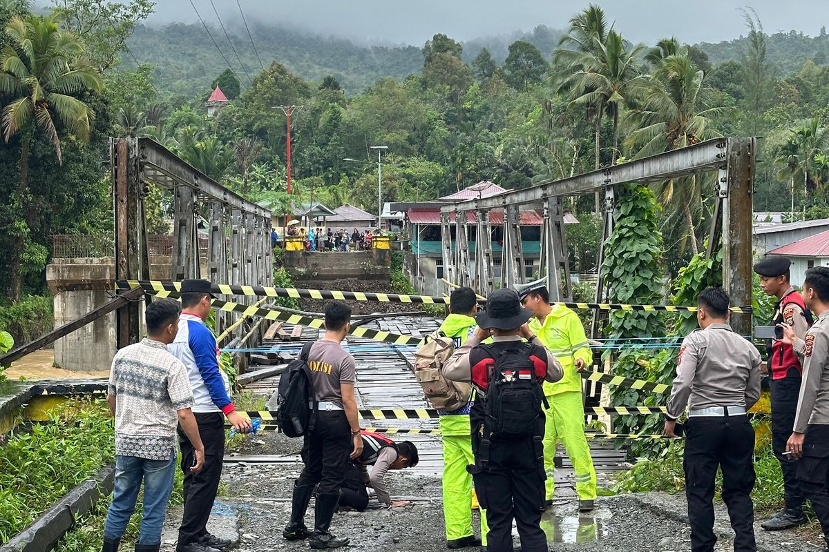 Polisi memasang police line di Jembatan Noyo di Kecamatan Mandrehe, Kabupaten Nias Barat, Sumatera Utara, Rabu (5/3/2025). Jembatan itu roboh karena diterjang banjir.    
