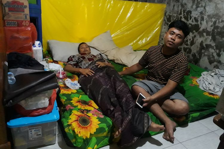 Aji Galuh Ramadan (20) merawat ibunya, Anik Ismawati (37) yang menderita penyakit kanker patudara stadium 4 di rumahnya, Kelurahan Sidotopo Wetan, Kecamatan Kenjeran, Surabaya, Jawa Timur, Rabu (29/1/2020).