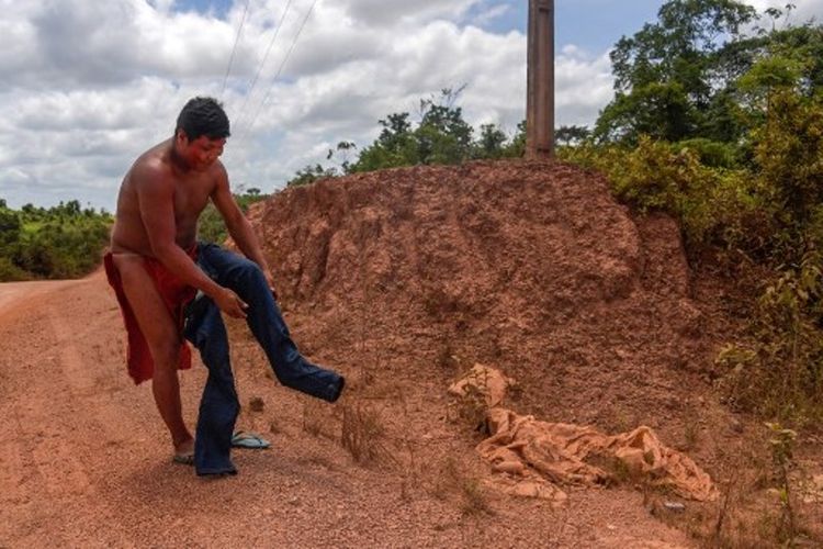 Kamon Waiapi mengenakan celanaya sebelum tiba di kota Pedra Branca, Amapa, Brasil, pada 15 Oktober 2017. (AFP/Apu Gomes)