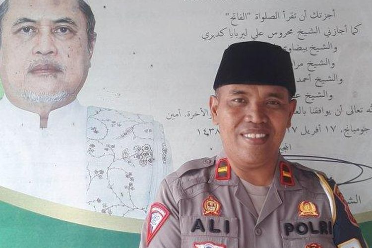 Ipda Ali Nur Suwandi berfoto bersama potret KH Djamaluddin Ahmad guru ngajinya di pesantren, Minggu (10/4/2023)   