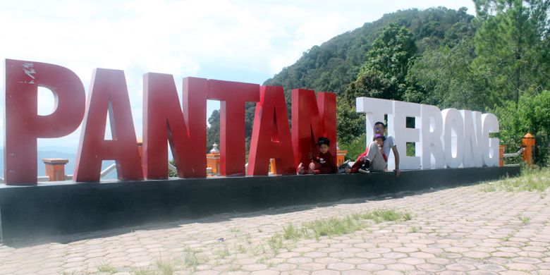 Wisatawan berfoto dengan latar tulisan Pantan Terong, di Desa Ulu Nuih, Kecamatan Bebesen, Kabupaten Aceh Tengah, Aceh.