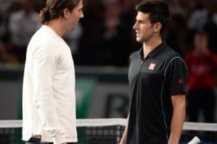 Petenis Serbia, Novak Djokovic (kanan) berbicara dengan pemain sepak bola Paris Saint-Germain asal Swedia, Zlatan Ibrahimovic, setelah melakukan aksi tenis hiburan di Bercy Palais-Omnisport, Paris. Mereka bermain setelah Djokovic mengalahkan Roger Federer pada laga semifinal Paris Masters, Sabtu (2/11/2013).