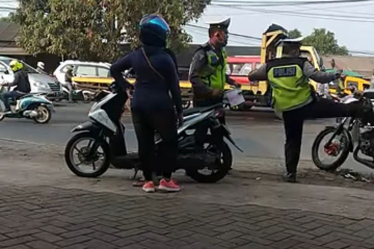 Seorang petugas polisi menendang pengendara di Cikupa, Kabupaten Tangerang, Jumat (30/8/2019)