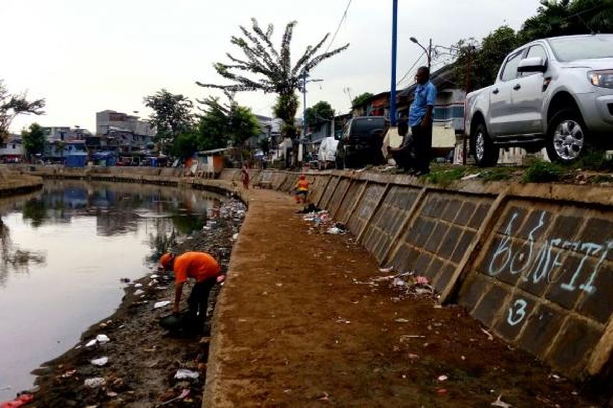 Petugas membersihkan Kali Ciliwung di belakang kantor kelurahan Kwitang, Senen, Jakarta Pusat, Senin (16/5/2016).