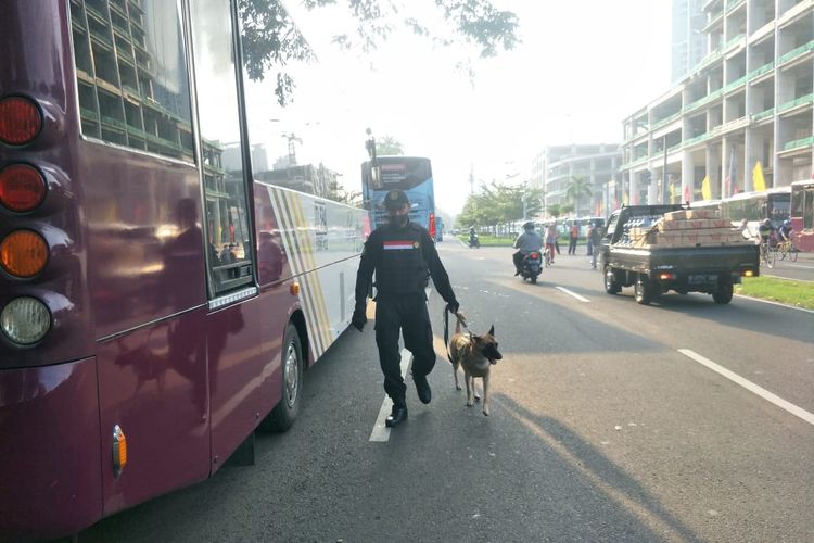 Petugas kepolisian dan anjing pelacak tengah memeriksa bus pengangkut penonton Formula E di kawasan JiExpo Kemayoran, Jakarta Pusat, Sabtu (4/6/2022).