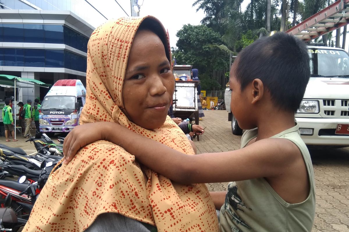 Farida dan anaknya yang berkebutuhan khusus, Ridho, saat bercerita kronologi banjir masuk ke rumahnya.