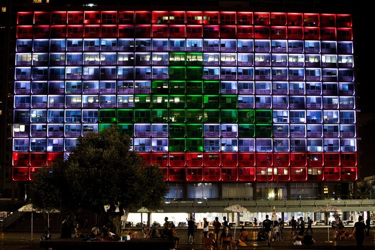 Orang-orang nongkrong di alun-alun Rabin saat gedung kota diterangi dengan warna-warna bendera Lebanon, dalam pertunjukan langka solidaritas Israel dengan Beirut karena ledakan dahsyat, di Tel Aviv, Israel 5 Agustus 2020.