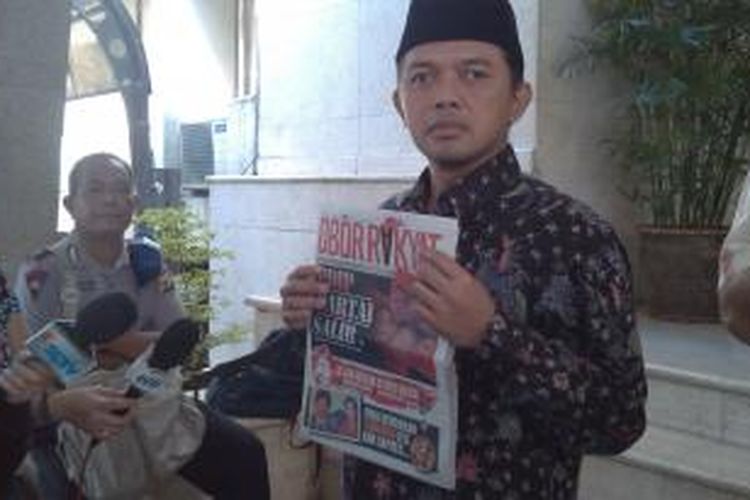 Pimpinan Ponpes Al Mizan Maman Imanulhaq memperlihatkan tabloid 