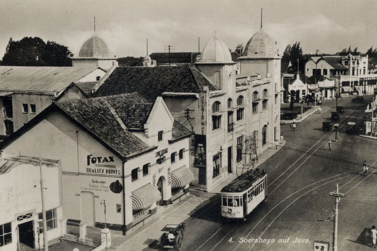 Trem listrik melintas di Jalan Gemblongan, tepatnya depan Hotel Yamato (sekarang Hotel Majapahit), Fotax Fotografisch Magazijn, dan Atelier di sisi kiri. Foto diambil tahun 1938.