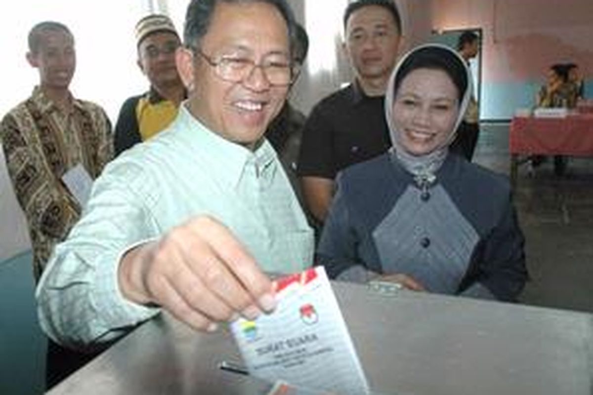 Calon wali kota Bandung Dada Rosada didampingi istri memasukan surat suara saat pencoblosan di TPS 46, Kelurahan Sarijadi, Kecamatan Sukasari, Bandung, Minggu (10/8). Pelaksanaan pemilihan wali kota/wakil wali kota Bandung berlangsung aman dan lancar.