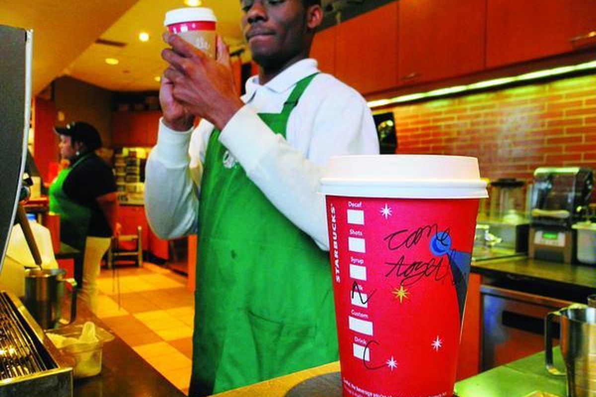 Seorang pegawai salah satu kedai kopi Starbucks di Washington DC, AS, menuliskan pesan 