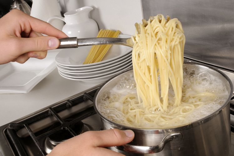 Ilustrasi rebus spageti dalam air mendidih. 