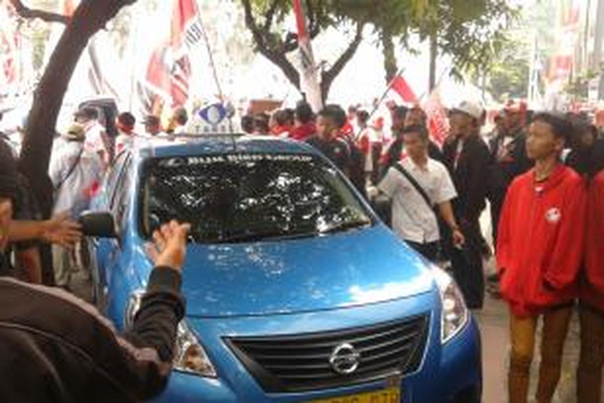 Taksi Blue Bird yang ditendang dan dipaksa menaiki trotoar oleh massa pendukung Prabowo, di Jalan MH Thamrin, Jakarta Pusat, Kamis (21/8/2014).