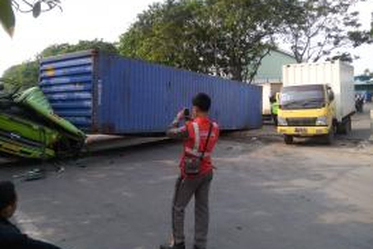 Sebuah truk kontainer dengan nomor polisi B 9095 UEL terguling di Jalan Yos Sudarso, Jakarta Utara Senin, (7/7/2014) siang. 