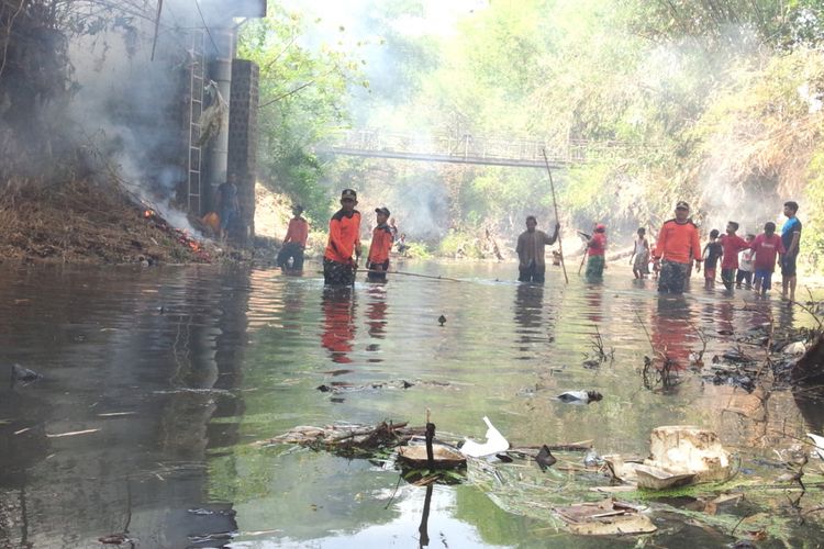 Para relawan membersihkan sampah yang berada di Kali Putih di Desa Selorejo, Kecamatan Mojowarno, Kabupaten Jombang, Minggu (04/11/2018).
