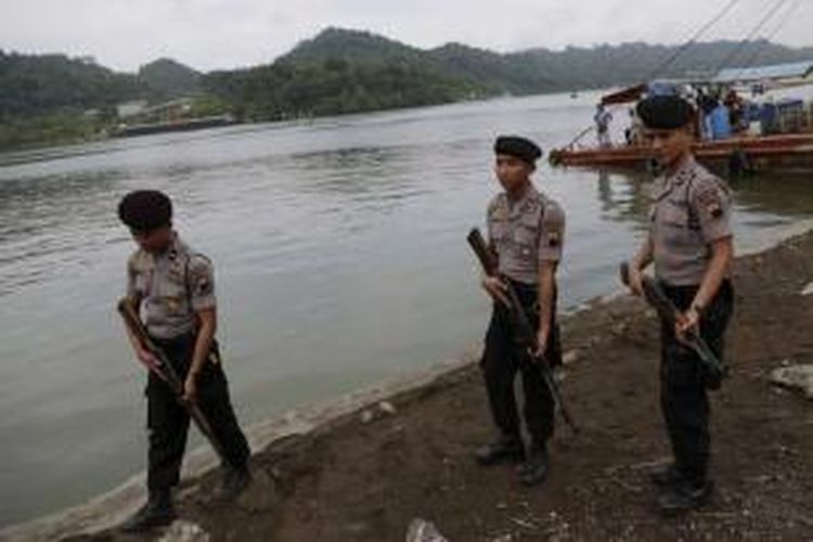 Polisi berjaga di Cilacap dengan latar belakang Pulau Nusakambangan tempat eksekusi dua terpidana mati kasus narkotika kelompok Bali Nine yaitu Andrew Chan dan Myuran Sukumaran, Rabu (4/3/2015).