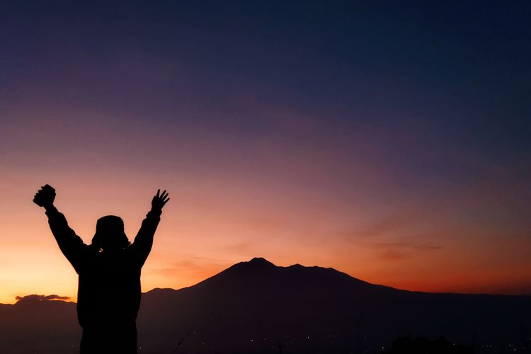 Seorang wisatawan tengah menikmati pemandangan Gunung Gede Pangrango detik-detik menjelang momen golden sunrise yang dilihat dari Desa Pasirjaya, Kecamatan Cigombong, Kabupaten Bogor pada Kamis (27/5/2021).