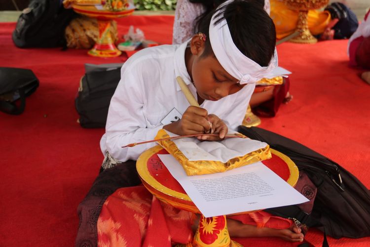 Siswa mengikuti lomba menulis aksara Bali Kamis (9/2/2023) di Wantilan Sasana Budaya Singaraja, Kabupaten Buleleng, Provinsi Bali.