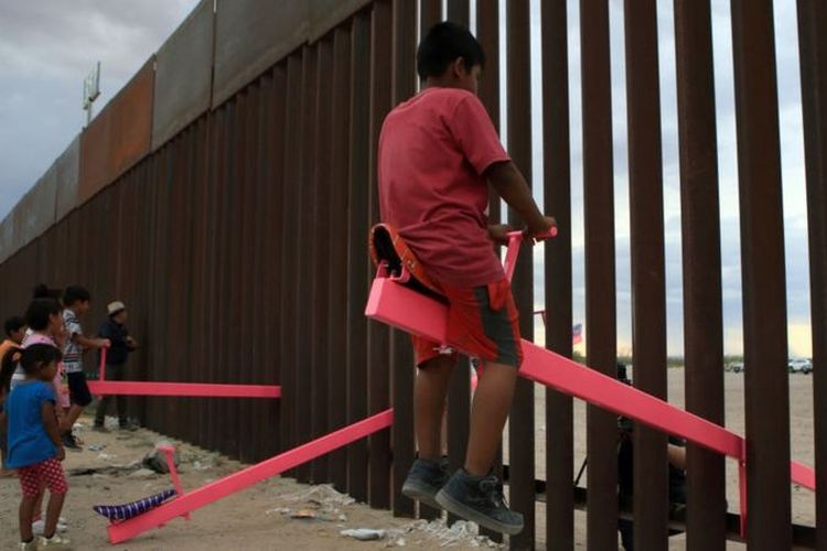 Jungkat-jungkit pink di tembok perbatasan AS-Meksiko.