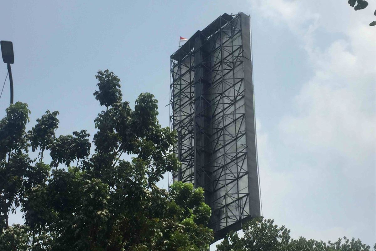 Seorang warga memanjat sebuah baliho di Jalan Slipi Petamburan, Jakarta Pusat. Aksi tersebut dilakukan tepat di depan Gedung Badan Pemeriksa Keuangan RI, Kamis (16/8/2018).  