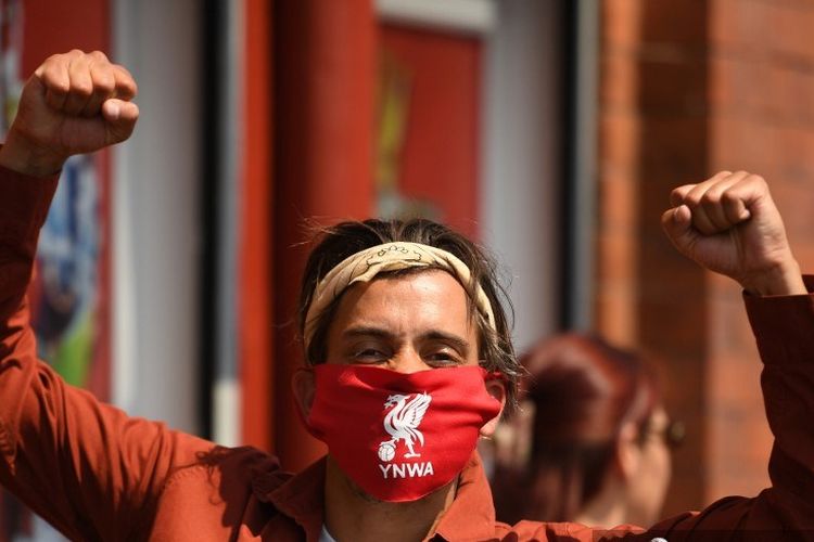 Seorang fan Liverpool di dekat Stadion Anfield sedang merayakan gelar juara Liga Inggris yang diraih Liverpool.