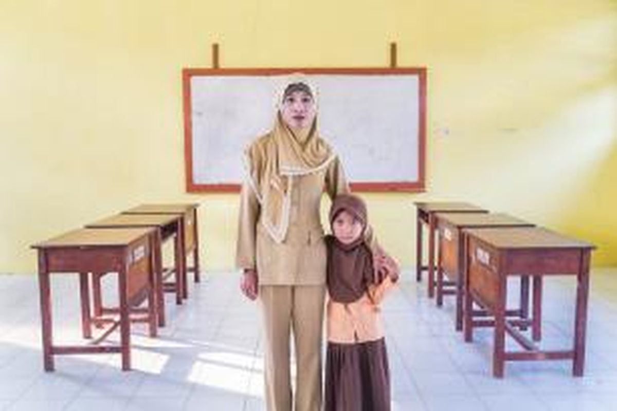 Ratna di ruang kelas tempatnya mengajar serta putrinya, Amel.