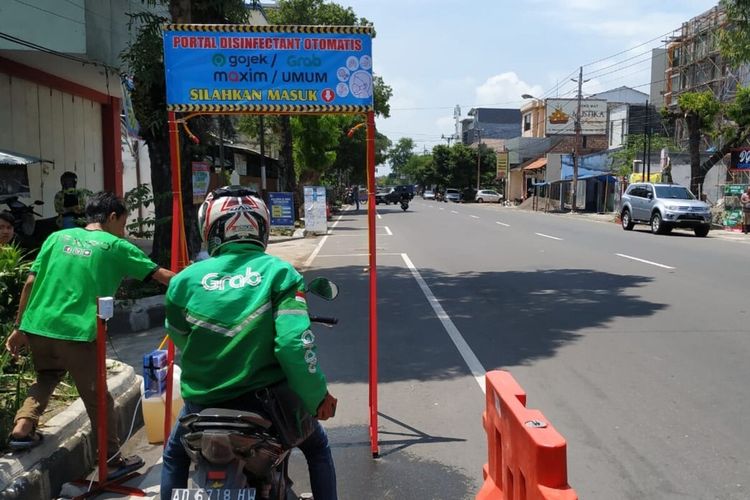 Portal disinfektan otomatis bagi driver ojol saat diuji coba di di Jalan Veteran No 62 Gajahan, Pasar Kliwon, Solo, Jawa Tengah, Minggu (29/3/2020).