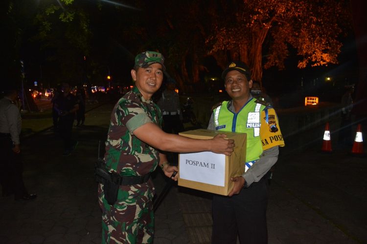 Dandim 0735/ Surakarta, Letkol Inf Ali Ahkwan memberikan bingkisan kepada anggota yang melakukan pengamanan Natal di Pos Sriwedari Solo, Jawa Tengah, Minggu (24/12/2017) malam.