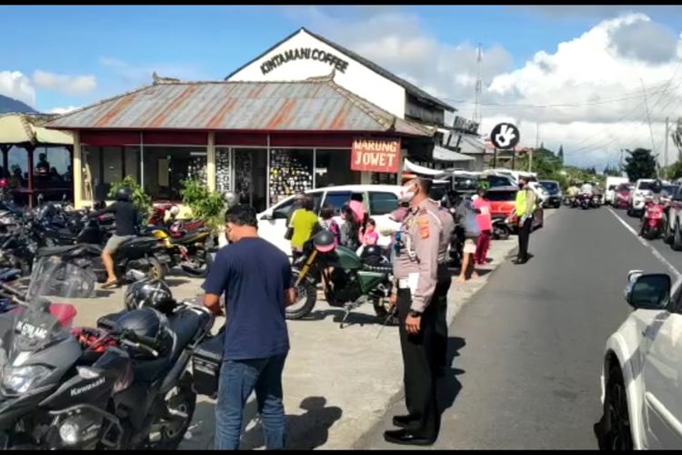 Polisi saat mengimbau warga agar menerapkan protokol kesehatan di Kawasan Kintamani, Bangli, Bali.