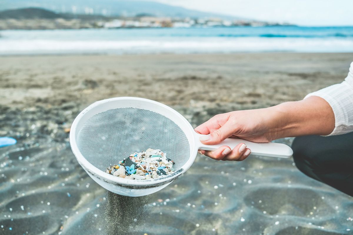 Ilustrasi mikroplastik di pantai yang mencemari laut. Dampak sampah plastik di lautan.