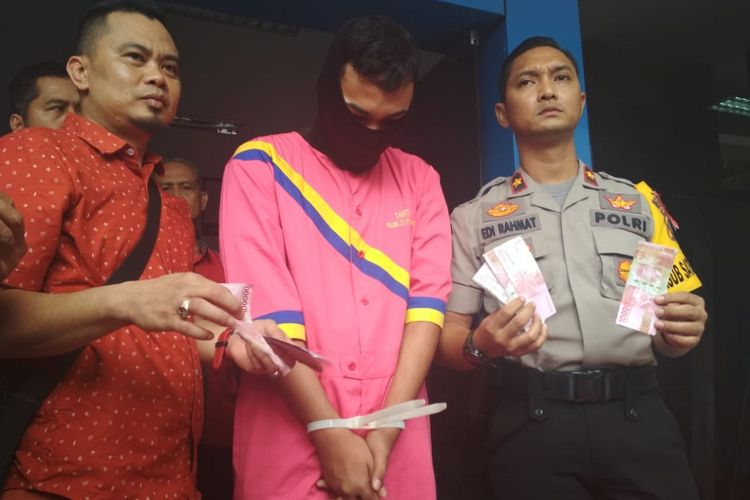 Haryadi (23) pelaku pemalsuan uang dengan menyewa salah satu PSK ketika diamankan di Polsek Ilir Timur I Palembang, Sumatera Selatan, Selasa (18/12/2018). Pelaku ditangkap polisi setelah dilaporkan oleh korban.