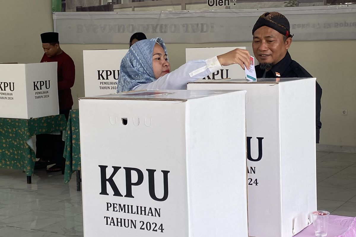 Seorang warga Kelurahan Duren Jaya, Bekasi Timur, Kota Bekasi tengah memasukan surat surat ke kotak suara pada hari pemungutan suara.
