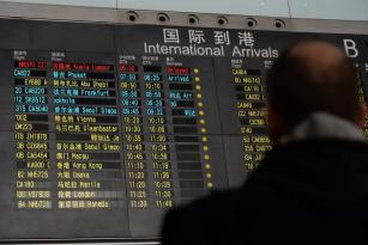 Papan pengumuman kedatangan penerbangan di Bandara Internasional Beijing menampilkan penerbangan Malaysia Airlines MH370 di posisi teratas dengan warna merah. Kata-kata 